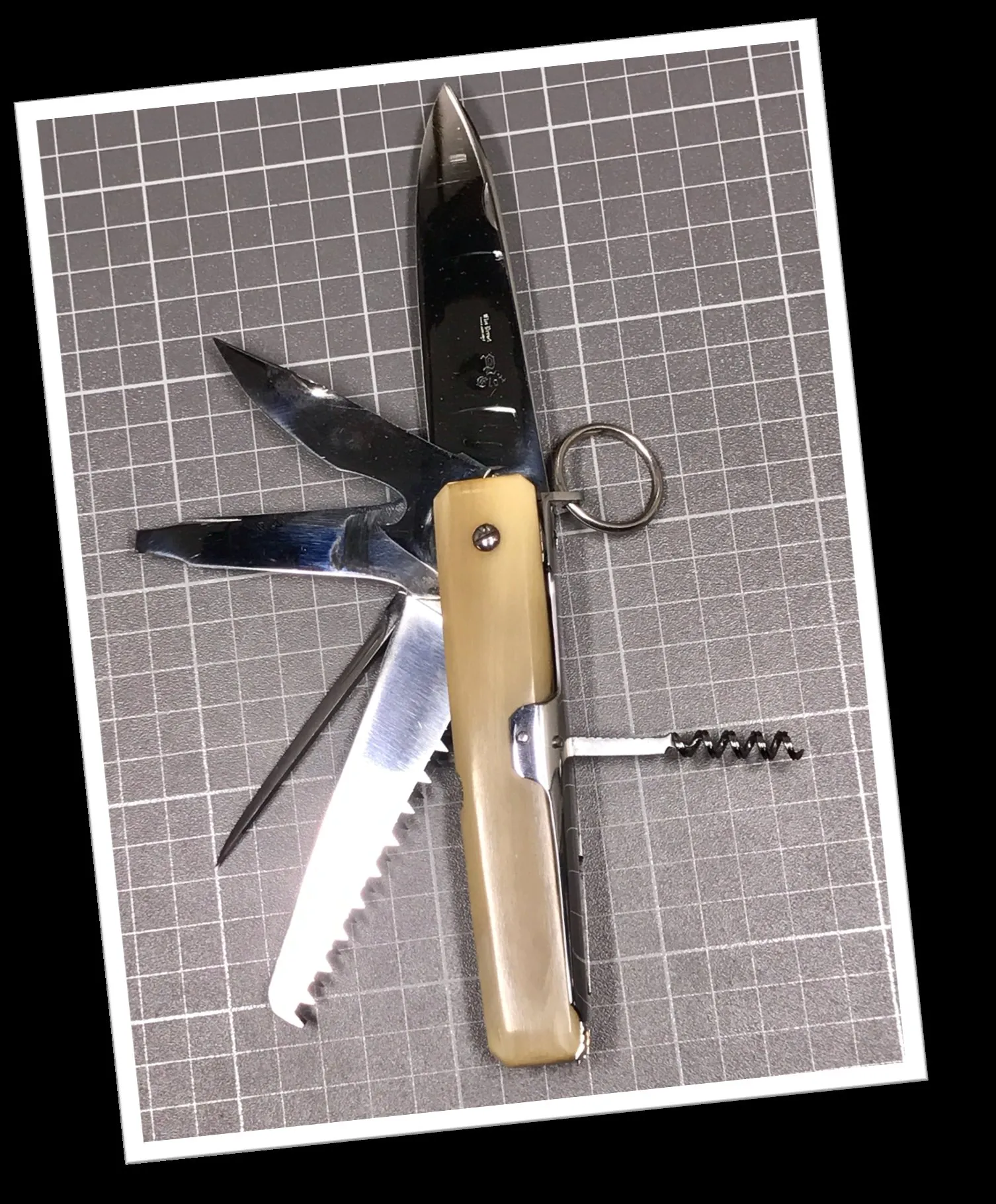 Couteau cran d'arrêt Eloi 1960 manche corne blonde octogonal, lames dépliées dont scie, corkscrew et poinçon visible